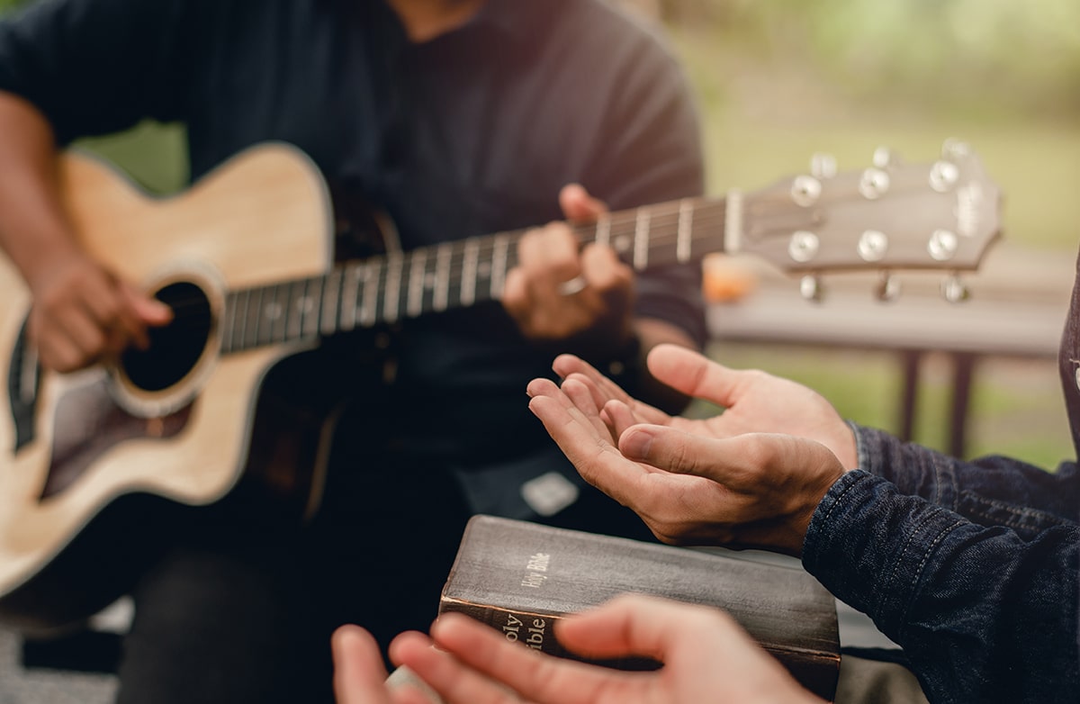 Christian Families Worshiping God Outdoors To relax life honoring God with a melodious guitar playing and the bible